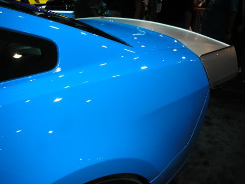 1998 Ford Crown Victoria - Close-up of a blue car's rear quarter panel and spoiler.