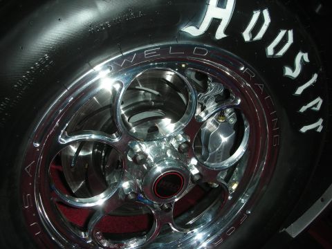 1998 Ford Crown Victoria - A close-up view of a polished Weld racing wheel and Hoosier tire, showing the brake caliper and rotor.