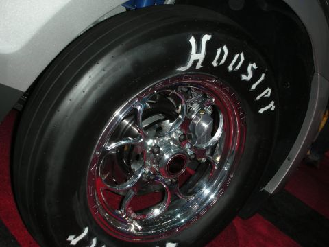 1998 Ford Crown Victoria - Close-up of a racing tire and wheel assembly, showing tire branding and wheel design.