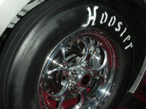 1998 Ford Crown Victoria - Close-up of a Hoosier drag racing tire mounted on a polished Weld Racing wheel, showing the brake system.