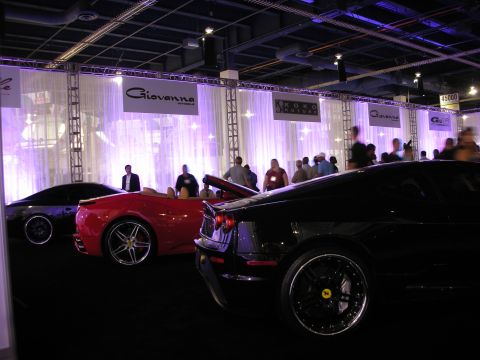 1998 Ford Crown Victoria - Several high-end sports cars are parked indoors at an event with banners and lighting.