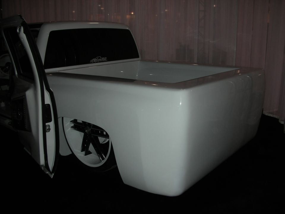 White customized pickup truck bed with custom wheels and lowered suspension