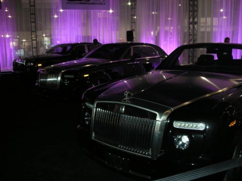 1998 Ford Crown Victoria - Multiple black Rolls-Royce vehicles are displayed under purple ambient lighting.
