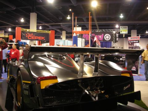 1998 Ford Crown Victoria - A black sports car with a prominent rear wing and quad exhaust pipes is displayed indoors.