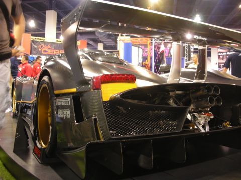 1998 Ford Crown Victoria - The rear view of a striking carbon fiber race car, quad exhaust pipes and prominent Pirelli tires.