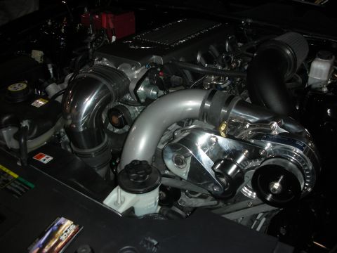 1998 Ford Crown Victoria - Close-up of a modified engine bay, showing a supercharger and intake system.