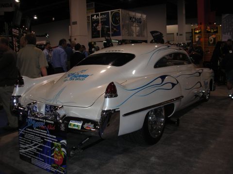 1998 Ford Crown Victoria - A custom white coupe with blue flame graphics and a display sign is seen at a show.