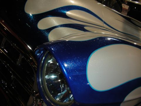 1998 Ford Crown Victoria - A close-up view of a vehicle's front fender shows a custom blue and silver flame paint job.