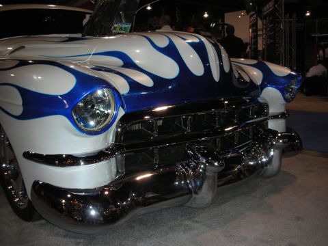 1998 Ford Crown Victoria - A heavily customized classic car with a striking flame paint job is displayed indoors.