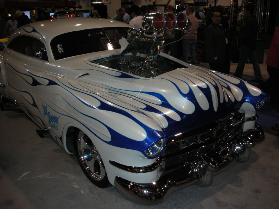 White hot rod with blue flames, exposed engine, and chrome bumper