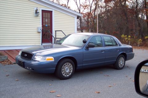 2001 Ford Crown Victoria - This 2001 Ford Crown Victoria is seen from the front three-quarter angle, parked in front of a building.
