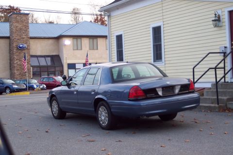 2001 Ford Crown Victoria - Rear view of a blue 2001 Ford Crown Victoria parked on an asphalt lot.
