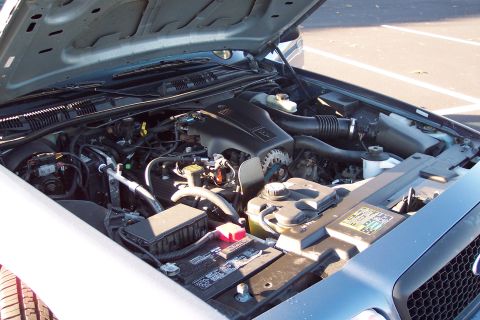 2001 Ford Crown Victoria - The engine bay of a Ford Crown Victoria is open, revealing its V8 engine and associated components.