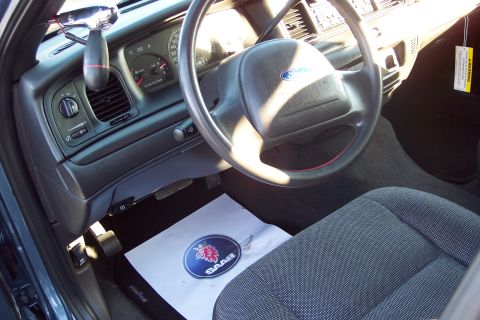2001 Ford Crown Victoria - The interior of a 2001 Ford Crown Victoria, the dashboard, steering wheel, and driver's seat.