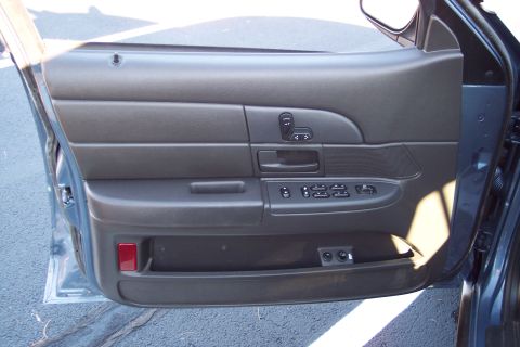 2001 Ford Crown Victoria - Close-up of a car's interior door panel with power window and lock controls visible.