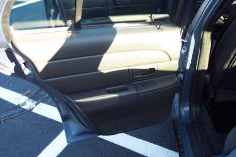 2001 Ford Crown Victoria - The interior of a 2001 Ford Crown Victoria, showing the driver's side rear door panel and part of the back seat.