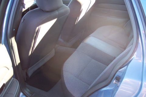 2001 Ford Crown Victoria - Rear interior of a blue 2001 Ford Crown Victoria, showing the seats and door trim.
