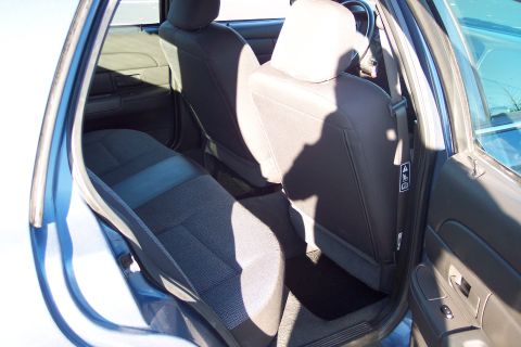 2001 Ford Crown Victoria - The interior of a blue 2001 Ford Crown Victoria is visible, focusing on the rear seating area and door.