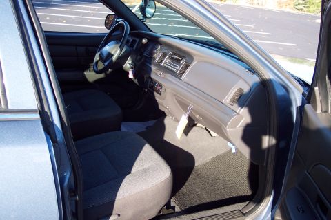 2001 Ford Crown Victoria - The interior of a police car, a standard dashboard and cloth seats.