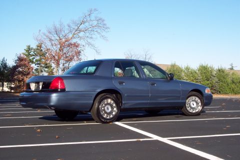 2001 Ford Crown Victoria - A blue 2001 Ford Crown Victoria is parked in a lot on a clear day.