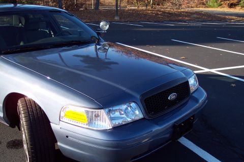 2001 Ford Crown Victoria - Front view of a blue 2001 Ford Crown Victoria police car parked in a lot.