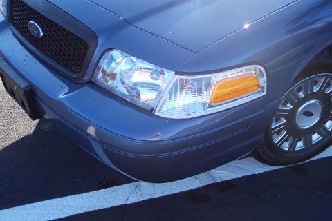 2001 Ford Crown Victoria - Front corner view of a blue 2001 Ford Crown Victoria, showing the headlight and grille.