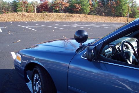 2001 Ford Crown Victoria - A blue police car is seen from the front quarter angle, a spotlight mounted on the hood and a view into the interior.