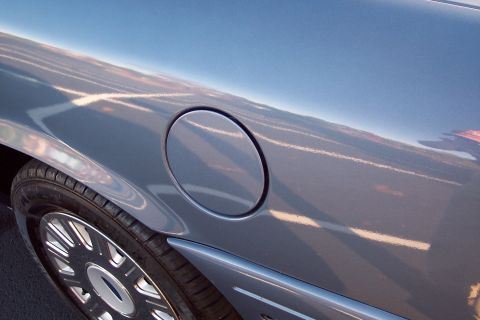 2001 Ford Crown Victoria - Close-up of the fuel door and wheel on a blue 2001 Ford Crown Victoria.