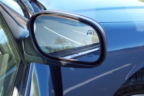 2001 Ford Crown Victoria - Side mirror on a blue vehicle displays a heated mirror icon and warning text.
