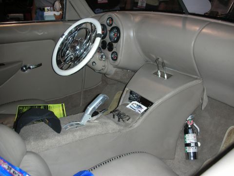 1998 Ford Crown Victoria - The interior of a custom vehicle features a unique steering wheel and a prominent gear shifter, with a fire extinguisher mounted nearby.