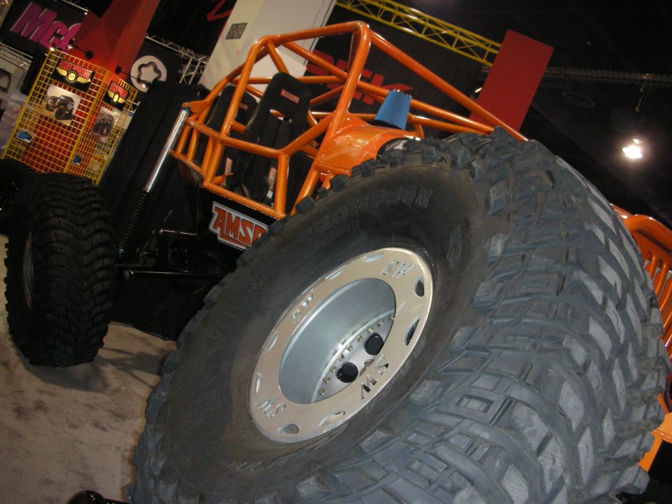 Orange off-road buggy with large tires and roll cage