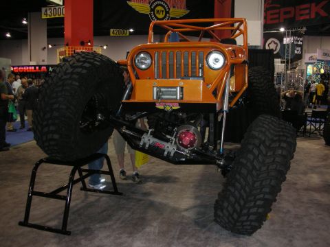 1998 Ford Crown Victoria - An extreme off-road vehicle is displayed indoors with its massive tires elevated.