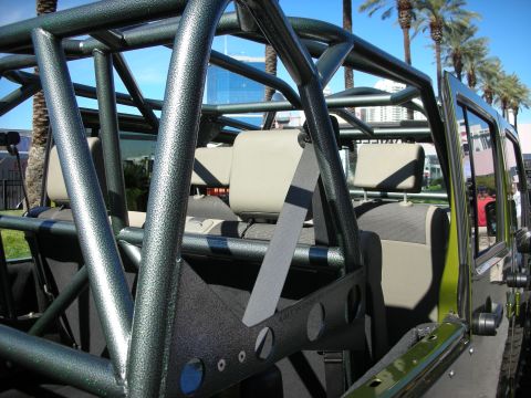1998 Ford Crown Victoria - The interior of a vehicle is visible, a prominent roll cage and tan seats, set against a backdrop of palm trees and urban buildings.