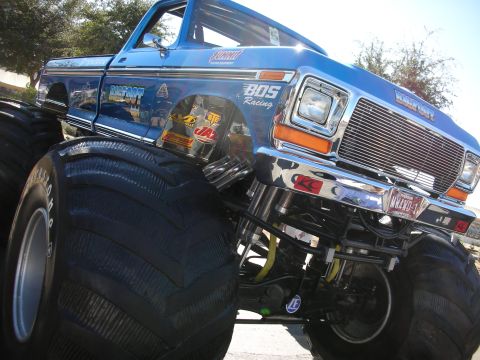 1998 Ford Crown Victoria - A close-up view of the iconic Bigfoot monster truck, its massive tires and custom racing graphics.