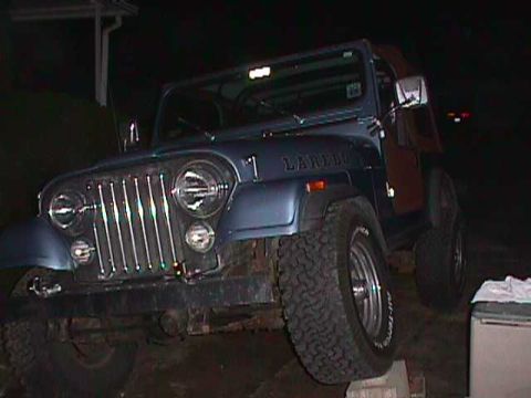 1984 Jeep Wrangler - Blue Jeep CJ-7 Laredo parked at night, showing its front 3/4 view and off-road tires.
