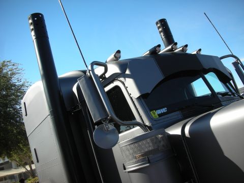 1998 Ford Crown Victoria - Close-up of a semi-truck's cab and exhaust pipes against a clear blue sky.