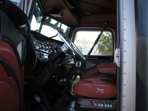 1998 Ford Crown Victoria - The custom interior of a large truck features plush leather seats and a detailed dashboard with numerous gauges.