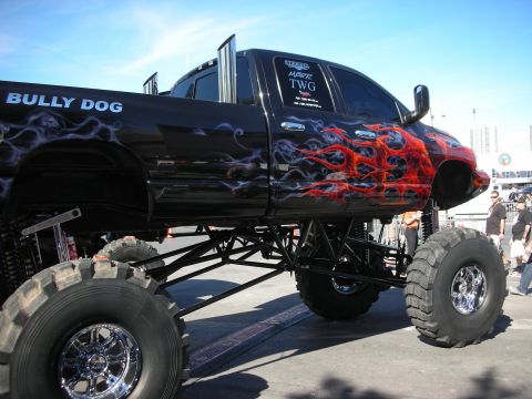 1998 Ford Crown Victoria - This heavily modified pickup truck features large tires, tall suspension, and custom flame graphics.