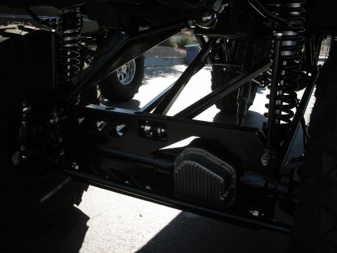 1998 Ford Crown Victoria - Close-up view of a heavily modified vehicle's undercarriage, highlighting custom suspension components and a differential cover.