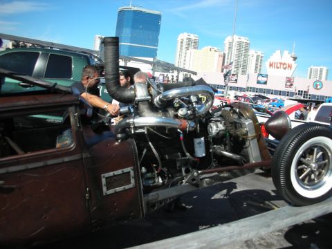 1998 Ford Crown Victoria - A heavily modified hot rod displays its complex engine and exhaust system at an outdoor event.
