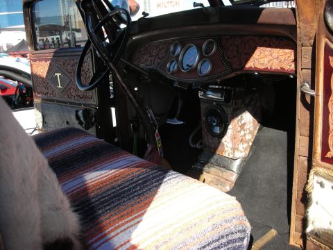 1998 Ford Crown Victoria - The interior of a vintage truck showcases custom tooling and a colorful seat cover.