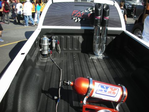 1998 Ford Crown Victoria - Customized pickup truck bed features an orange Nitrous Express bottle and large chrome exhaust stacks.