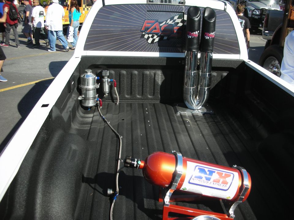 Pickup truck bed with orange Nitrous Express bottle and dual exhaust stacks