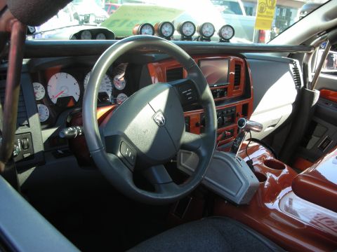 1998 Ford Crown Victoria - The interior of a truck features a roll cage, multiple gauges, and custom wood trim accents.