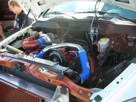 1998 Ford Crown Victoria - Customized engine bay a large turbocharger and prominent intercooler piping, with visible branding from Industrial Injection.