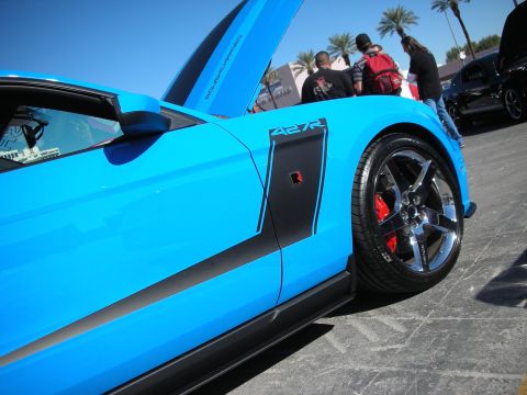 1998 Ford Crown Victoria - A bright blue sports car with racing stripes and custom wheels is displayed outdoors.