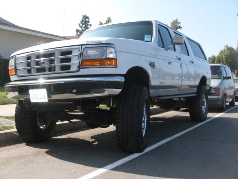 1996 Ford C-350 (Centurion Conversions) - This white 1996 Ford C-350 Centurion Conversions SUV is shown from the front 3/4 view, large tires and a prominent grille.