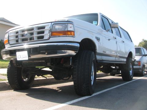 1996 Ford C-350 (Centurion Conversions) - Lifted 1996 Ford C-350 (Centurion Conversions) parked on a street with another vehicle behind it.
