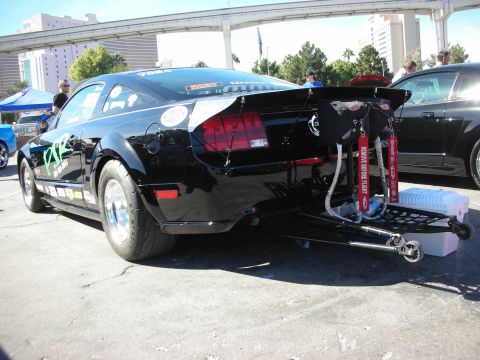 1998 Ford Crown Victoria - A black Ford Mustang drag car is parked outdoors, with a second black car visible to the right.