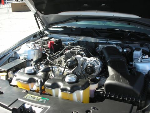 1998 Ford Crown Victoria - Engine bay of a silver car, showing a supercharger and various engine components.